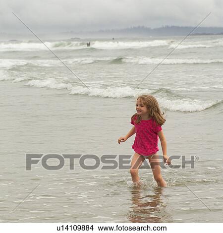 Girl standing in water on beach View Large Photo Image Picture - Girl standing in water on beach. Fotosearch