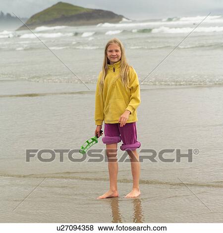 Stock Photo - Girl standing on beach, Pacific Rim Park, Vancouver Island, Canada. Fotosearch