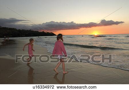 Stock Image - Kids playing on beach - Hawaii. Fotosearch