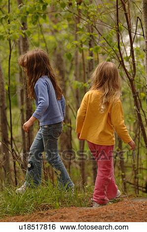 Stock Photograph - Two girls walking through forest. Fotosearch