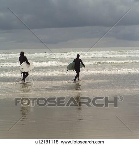 Stock Photo - Surfers with surfboards on beach, Pacific Rim Park, Vancouver Island, Canada. Fotosearch