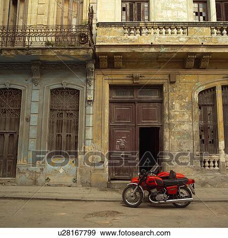 Stock Photo - Motorcycle parked outside an ancient building. Fotosearch