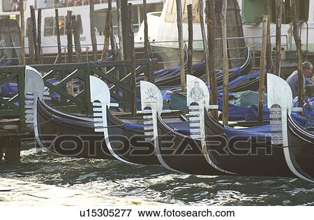 Array of gondolas docked at a canal in Venice, Italy View Large Photo Image Stock Photo - Array of gondolas docked at a canal in Venice, Italy. Fotosearch
