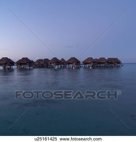 Stock Photography - Bungalows at Dusk at Moorea in Tahiti. Fotosearch