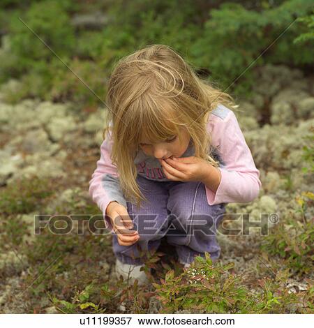 Stock Photo - 4 year old eating just picked berries. Fotosearch