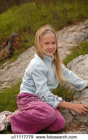 Stock Photo - Blond girl sitting on the ground. Fotosearch