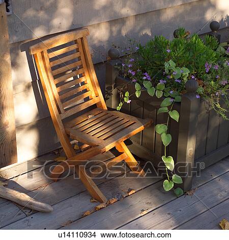 Picture - Empty chair beside flower pot. Fotosearch