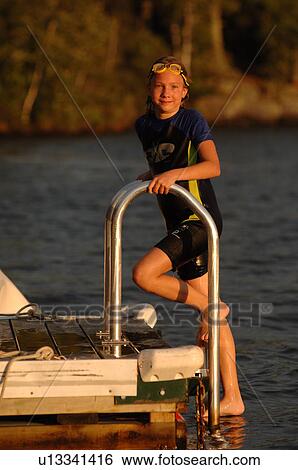 Girl climbing onto a dock at Lake of the Woods View Large Photo Image Stock Photograph - Girl climbing onto a dock at Lake of the Woods. Fotosearch