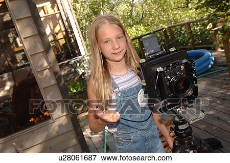 Girl standing beside a camera View Large Photo Image Stock Photo - Girl standing beside a camera. Fotosearch