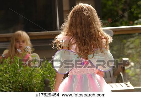 Picture - Rear view of a young girl wearing a fairy costume. Fotosearch