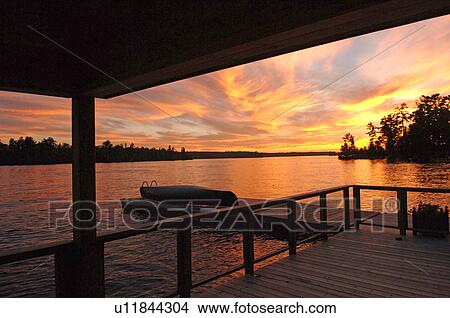 Silhouette of a deck with sunset over lake View Large Photo Image Picture - Silhouette of a deck with sunset over lake. Fotosearch