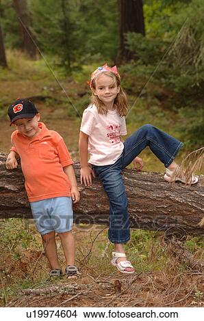 Two children climbing over a log View Large Photo Image Picture - Two children climbing over a log. Fotosearch