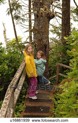 Stock Photo - Two girls climbing stairs in forest. Fotosearch