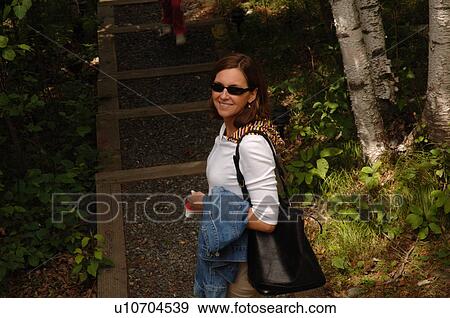 Woman in sunglasses smiling a camera View Large Photo Image Stock Photo - Woman in sunglasses smiling a camera. Fotosearch