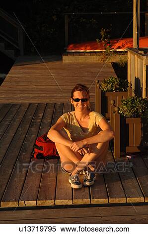 Woman sitting on a dock at twilight View Large Photo Image Stock Photography - Woman sitting on a dock at twilight. Fotosearch