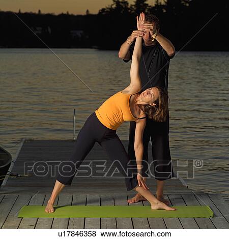 Stock Photo - Adult male and female doing yoga. Fotosearch