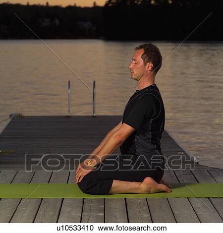Stock Image - Adult male doing yoga. Fotosearch