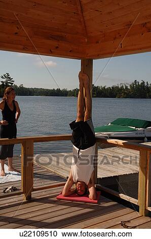 Man doing a headstand yoga position View Large Photo Image Stock Image - Man doing a headstand yoga position. Fotosearch