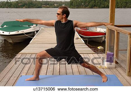 Stock Photograph - Man doing yoga on an outdoor deck. Fotosearch