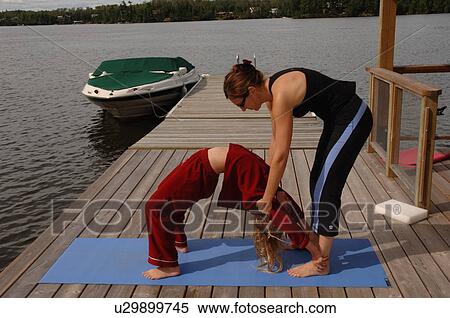 Stock Photography - People doing yoga outdoors. Fotosearch