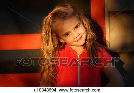 Picture - Young girl looking at camera smiling. Fotosearch