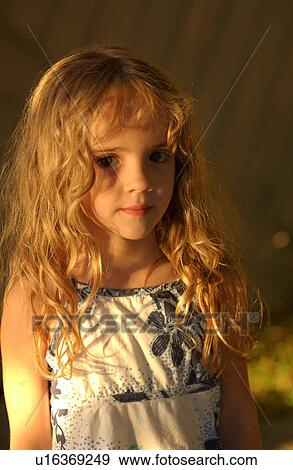 Stock Photo - Young girl looking at camera smiling. Fotosearch