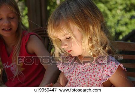 Stock Photo - Young girl sitting looking down. Fotosearch