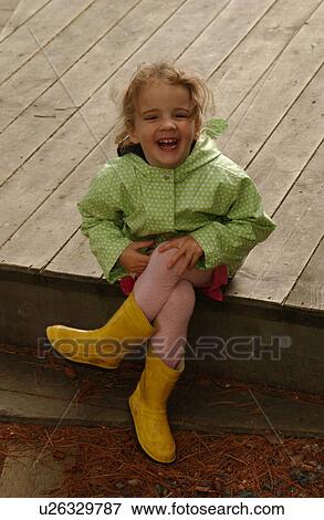 Young girl sitting on a pier laughing View Large Photo Image Stock Photo - Young girl sitting on a pier laughing. Fotosearch