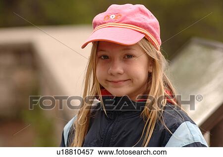 Stock Photo - Blond girl in pink hat smiling at camera, Jasper National Park, Canada. Fotosearch
