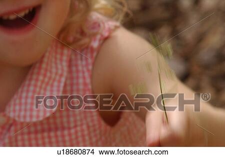 Picture - Close-up of a young girl holding a plant. Fotosearch