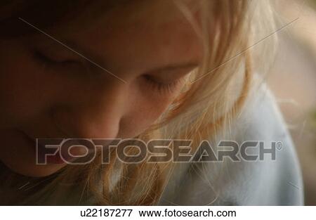 Stock Photo - Close-up of a young girl looking down. Fotosearch