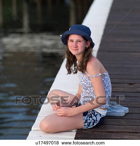 Girl sitting on dock View Large Photo Image Stock Photo - Girl sitting on dock. Fotosearch