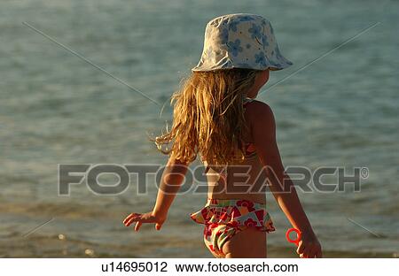 Rear of a young girl on a beach View Large Photo Image Stock Image - Rear of a young girl on a beach. Fotosearch