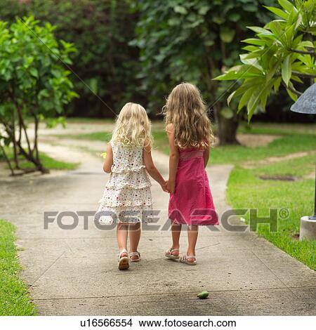 Picture - Two Young Girls Walking Down Path at Moorea in Tahiti. Fotosearch