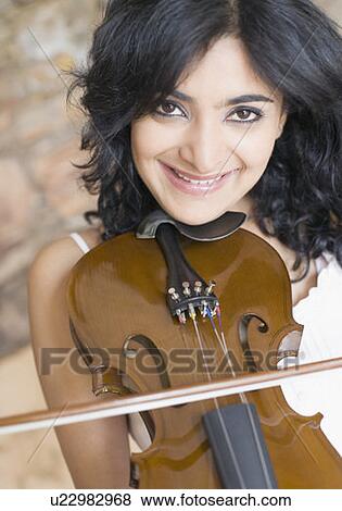 Portrait of a young woman playing a violin and smiling View Large Photo Image Stock Photo - Portrait of a young woman playing a violin and smiling. Fotosearch