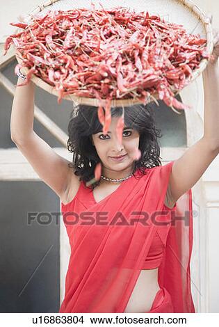 Portrait of a young woman spraying red chili peppers from a tray View Large Photo Image Picture - Portrait of a young woman spraying red chili peppers from a tray. Fotosearch