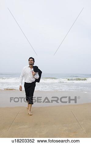 Businessman walking on the beach View Large Photo Image Stock Image - Businessman walking on the beach. Fotosearch