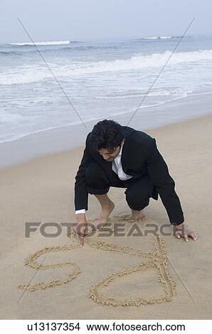 Businessman writing in sand on the beach View Large Photo Image Picture - Businessman writing in sand on the beach. Fotosearch