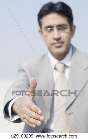 Stock Photo - Close-up of a businessman extending his hand for handshake. Fotosearch