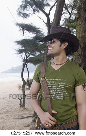 Close-up of a young man standing on the beach and smiling View Large Photo Image Stock Photo - Close-up of a young man standing on the beach and smiling. Fotosearch