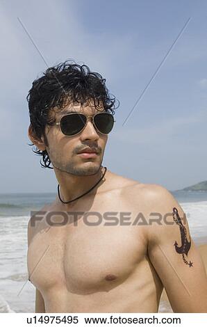 Close-up of a young man standing on the beach View Large Photo Image Stock Photography - Close-up of a young man standing on the beach. Fotosearch