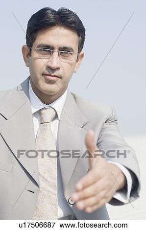 Portrait of a businessman holding his hand out View Large Photo Image Stock Photo - Portrait of a businessman holding his hand out. Fotosearch