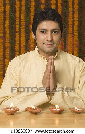 Stock Photo - Portrait of a mid adult man praying on diwali. Fotosearch