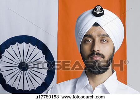 Stock Image - Portrait of a young man in front of an Indian flag. Fotosearch