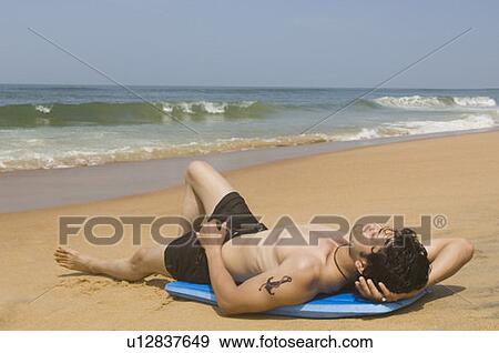 Stock Photo - Young man lying on a body board. Fotosearch
