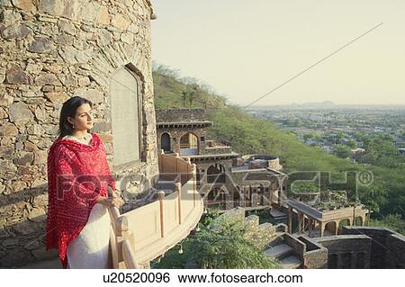Mid adult woman standing at the balcony of a fort, Neemrana Fort Palace, Neemrana, Alwar, Rajasthan, India View Large Photo Image Stock Photograph - Mid adult woman standing at the balcony of a fort, Neemrana Fort Palace, Neemrana, Alwar, Rajasthan, India. Fotosearch