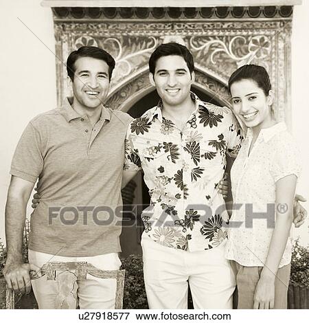 Stock Photo - Portrait of a young man standing with his friends and smiling. Fotosearch