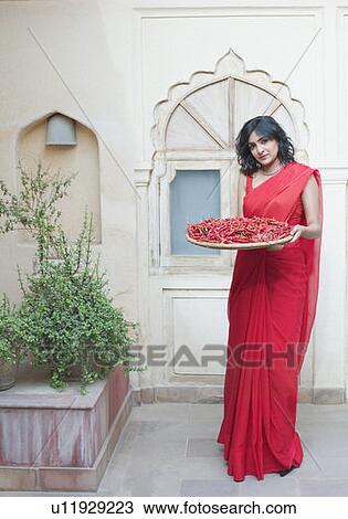 Portrait of a young woman holding a basket of red chili pepper View Large Photo Image Stock Image - Portrait of a young woman holding a basket of red chili pepper. Fotosearch