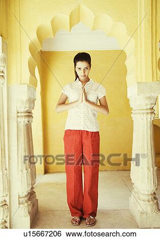 Portrait of a young woman making a greeting gesture View Large Photo Image Stock Photograph - Portrait of a young woman making a greeting gesture. Fotosearch