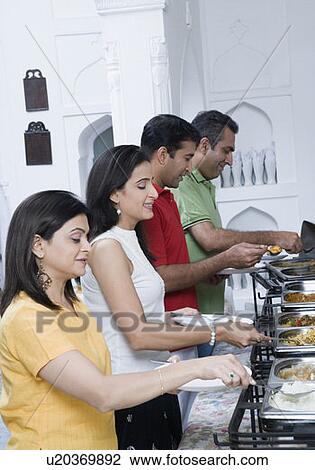 Side profile of two mid adult couples having food in a party View Large Photo Image Stock Image - Side profile of two mid adult couples having food in a party. Fotosearch